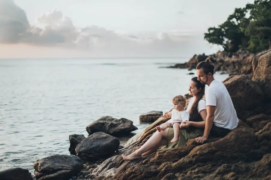 A serene family moment by the seaside, capturing love and relaxation at sunset.